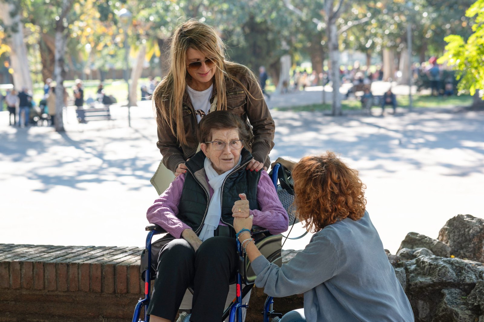 Voluntarios reconfortando a una mujer mayor en silla de ruedas